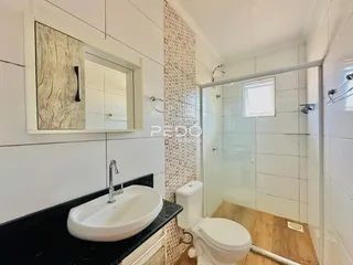 Foto de um banheiro com revestimento de azulejos e box de vidro.