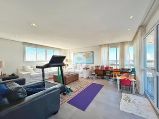 Sala de estar iluminada com vista para a paisagem urbana.