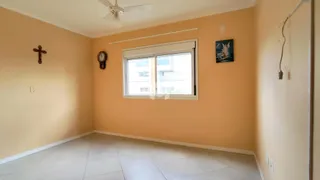 Foto de uma sala com paredes alaranjadas e piso de cerâmica.