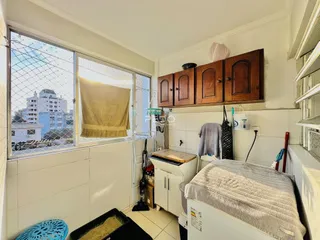Quarto com grande janela e armário de madeira.
