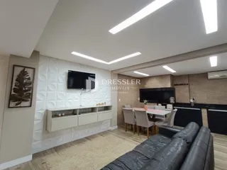 Sala de estar moderna com sofá e área de jantar em um apartamento.