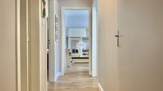 Hall de entrada com piso de madeira clara.