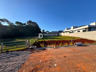 Vista externa da propriedade com cerca e área gramada.