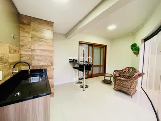 Interior de uma cozinha ou área social com piso branco e revestimento de madeira.