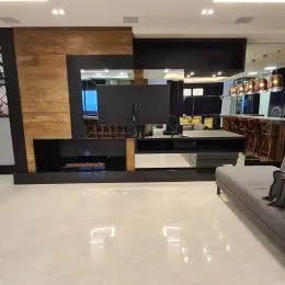 Sala de estar com parede de madeira e lareira moderna.