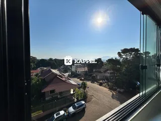 Vista da rua residencial em Lajeado, mostrando casas e vegetação sob um céu claro.