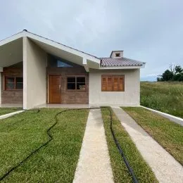 Foto da fachada de uma casa em Lajeado, Brasil, com gramado em primeiro plano.