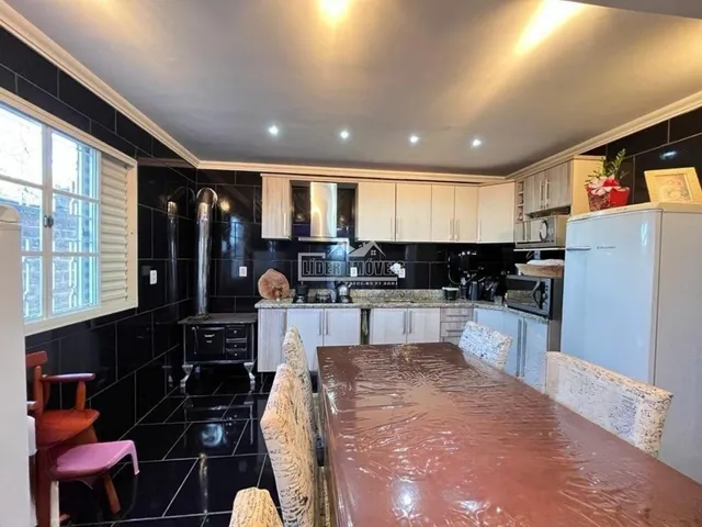 Foto de uma cozinha com armários brancos e piso preto em Lajeado.