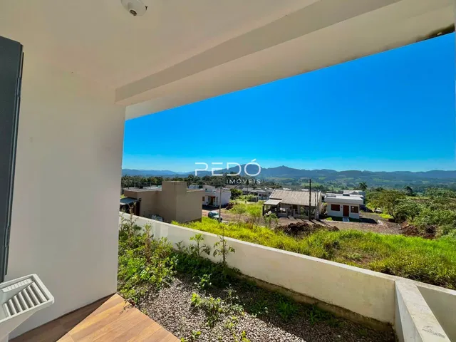 Vista da propriedade com paisagem verde e céu azul.