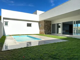 Fachada moderna de uma residência com piscina e jardim.
