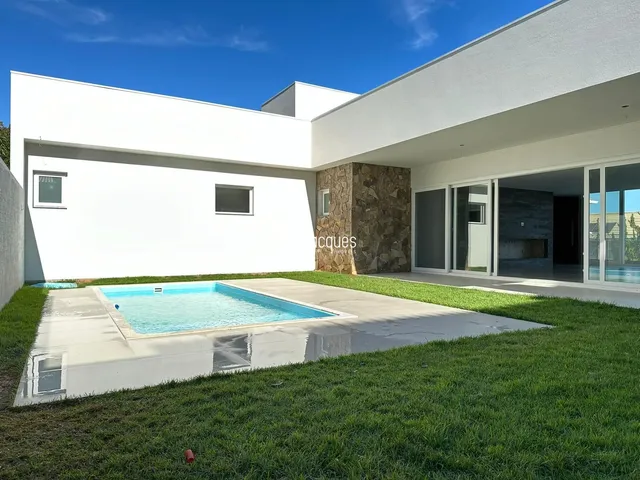 Fachada moderna de uma residência com piscina e jardim.