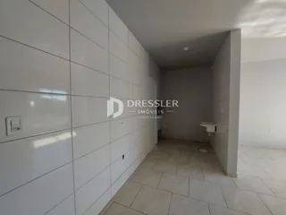 Corredor interno com paredes brancas e piso de cerâmica.