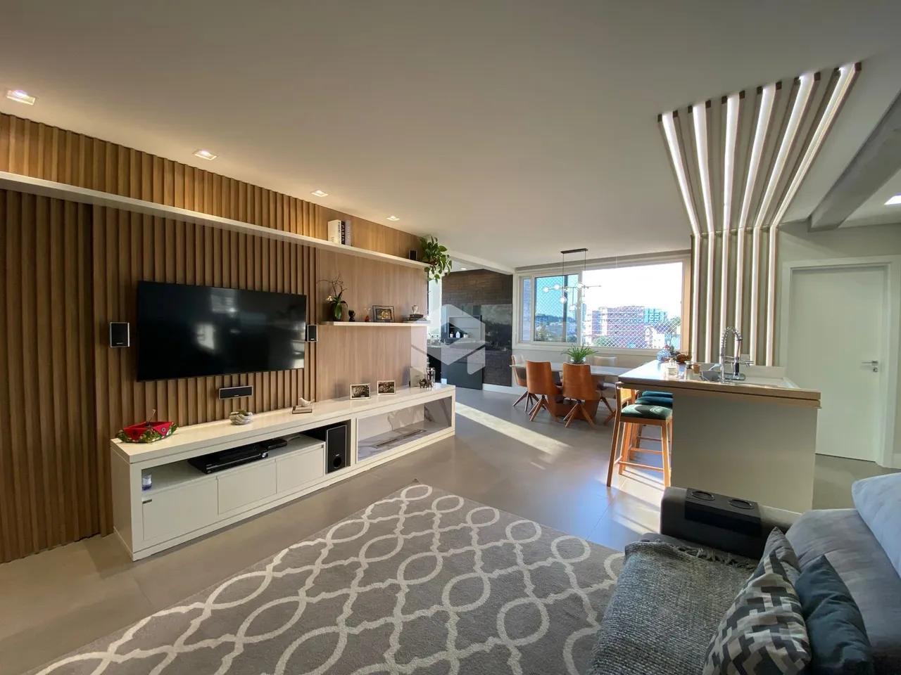 Sala de estar moderna com painel de madeira e vista da cidade.
