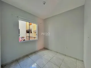 Vista interna de um corredor com piso de cerâmica e janela.