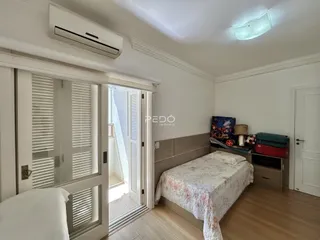 Quarto com porta de vidro e piso de madeira.