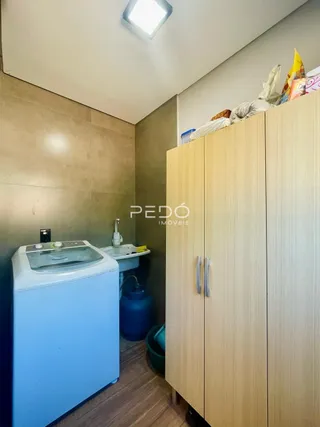 Vista interna de um cômodo com armário e máquina de lavar roupa.
