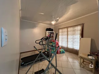 Interior de uma sala com piso de cerâmica e teto de sancas.