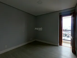 Uma sala de estar com paredes cinzas e piso de madeira clara.