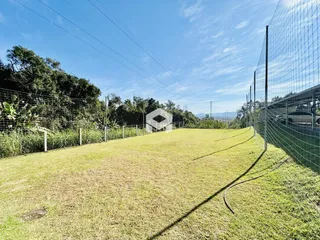 Campo gramado cercado por cerca de arame.