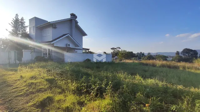 Vista da fachada de uma casa em Lajeado, Brasil, com gramado em primeiro plano.