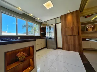 Interior de uma sala de estar com grandes janelas e acabamentos modernos.