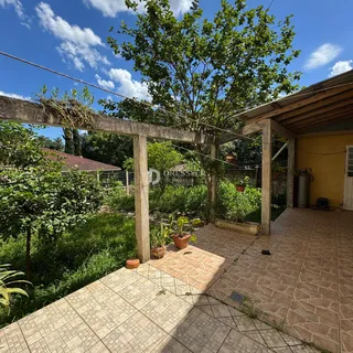 Vista de uma área externa com piso de cerâmica e vegetação.