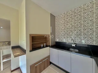Vista da cozinha com armários de madeira e revestimento de parede.