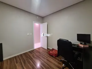 Interior de uma sala com piso de madeira e porta aberta.