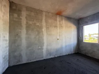 Parede de concreto aparente de um cômodo em construção.