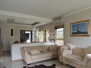 Imagem de uma sala de estar com sofá e parede em um imóvel.