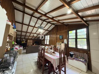 Interior de uma sala com teto de madeira e vigas expostas.