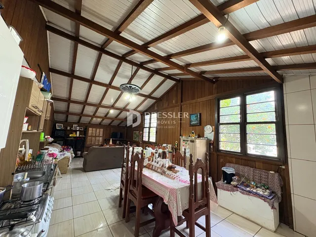 Interior de uma sala com teto de madeira e vigas expostas.