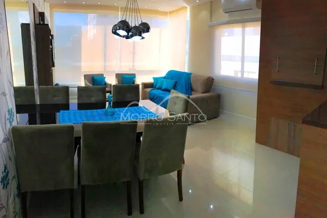 Sala de estar com sofás e luminária pendente em um ambiente claro.