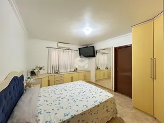 Quarto com cama e armário em ambiente claro.