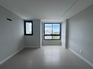Vista interna de um ambiente com paredes brancas e piso claro.