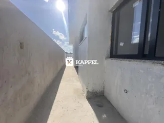 Foto de um corredor externo estreito entre duas paredes brancas.