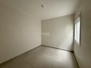 Vista interna de um ambiente com piso de cerâmica e paredes brancas.