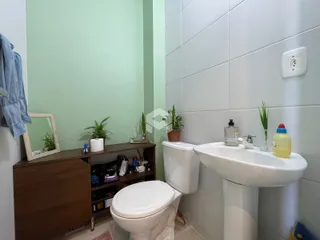 Foto de um banheiro com azulejos brancos e móveis de madeira.