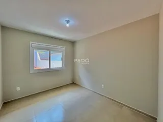 Ambiente interno de uma sala com piso claro e paredes lisas.