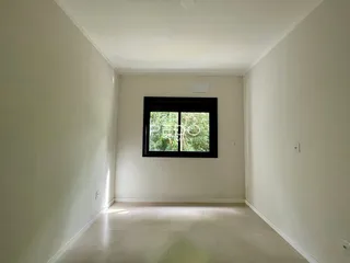 Hall de entrada com piso claro e paredes brancas.