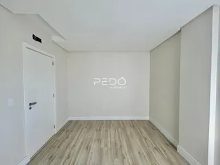 Ambiente interno de uma sala com piso de madeira clara.