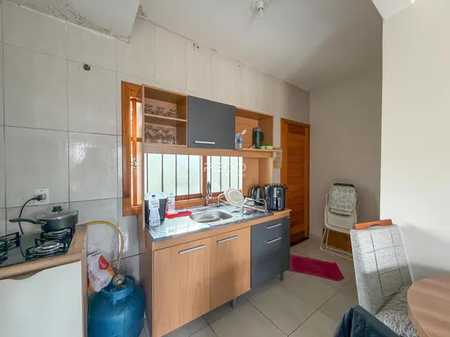 Vista da cozinha com armários de madeira e bancada.