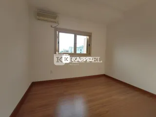 Foto de um ambiente interno com piso de madeira e uma janela.