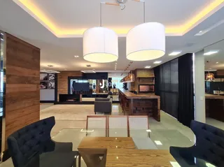 Sala de estar moderna com piso de madeira e iluminação em LED.