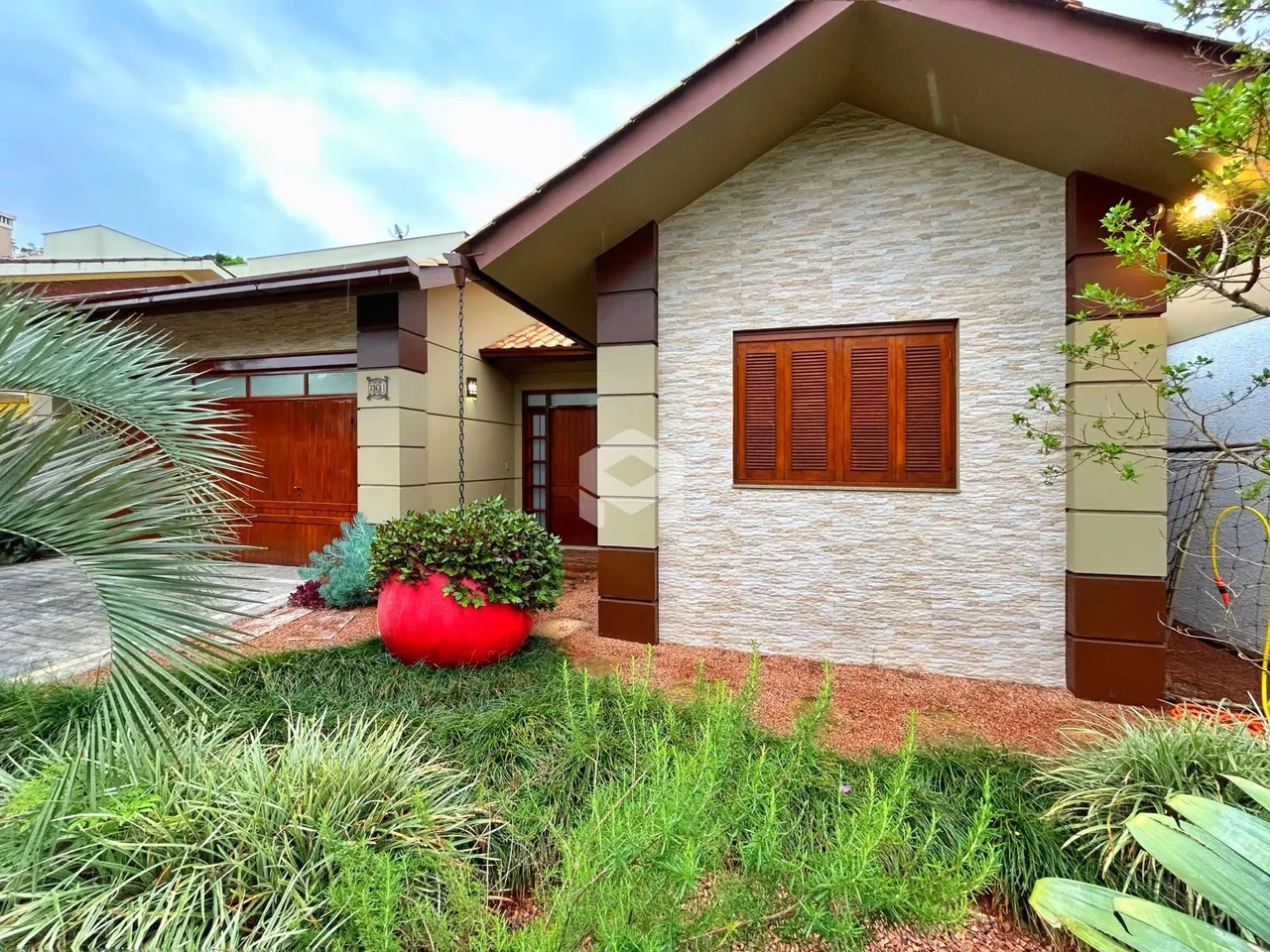 Fachada de uma residência em Lajeado, Brasil com jardim na frente.