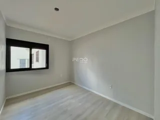 Sala de estar com paredes cinzas e piso de madeira clara.
