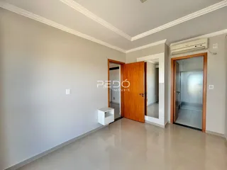 Corredor interno com paredes brancas e piso de cerâmica.