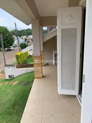 Foto de uma área externa com piso de cerâmica e vegetação ao fundo.