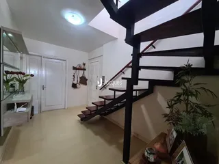 Interior de um corredor com escadaria em uma residência.