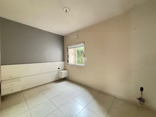 Sala de estar com piso de cerâmica clara e parede cinza.